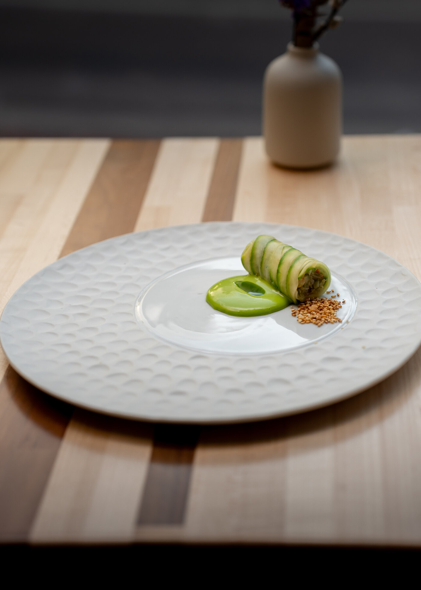 Finished rolled course with green sauce on a white plate